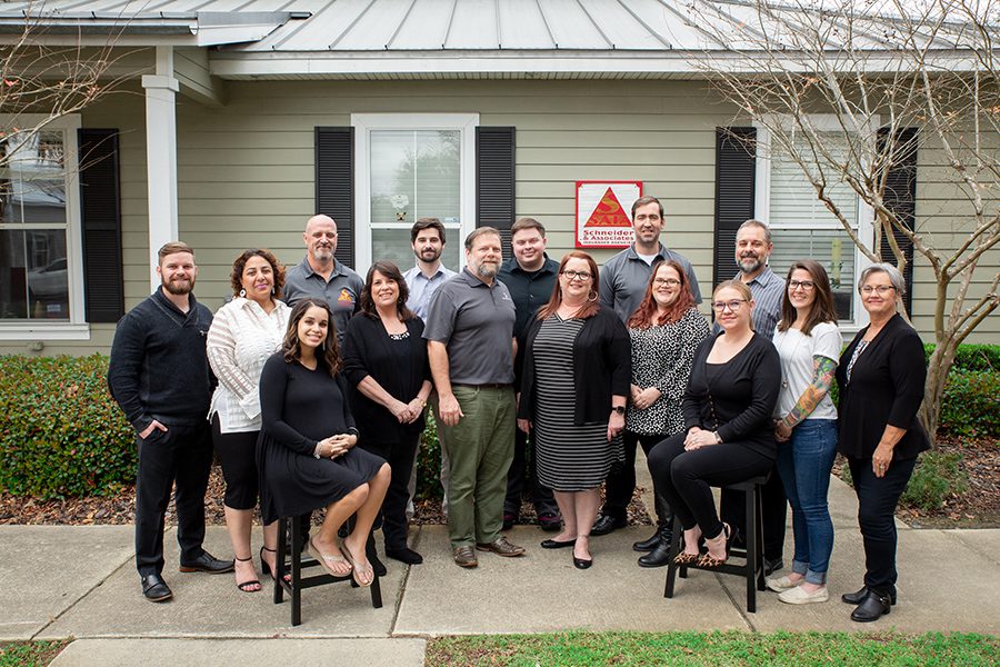 About Our Agency - Happy Team of Schneider and Associates Insurance Agencies Posing For a Group Portrait in Front of Office