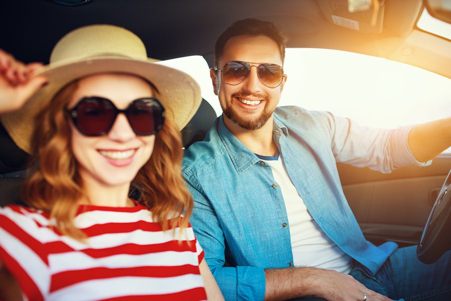 Personal Insurance - Happy Couple in Their Car Traveling in the Summer